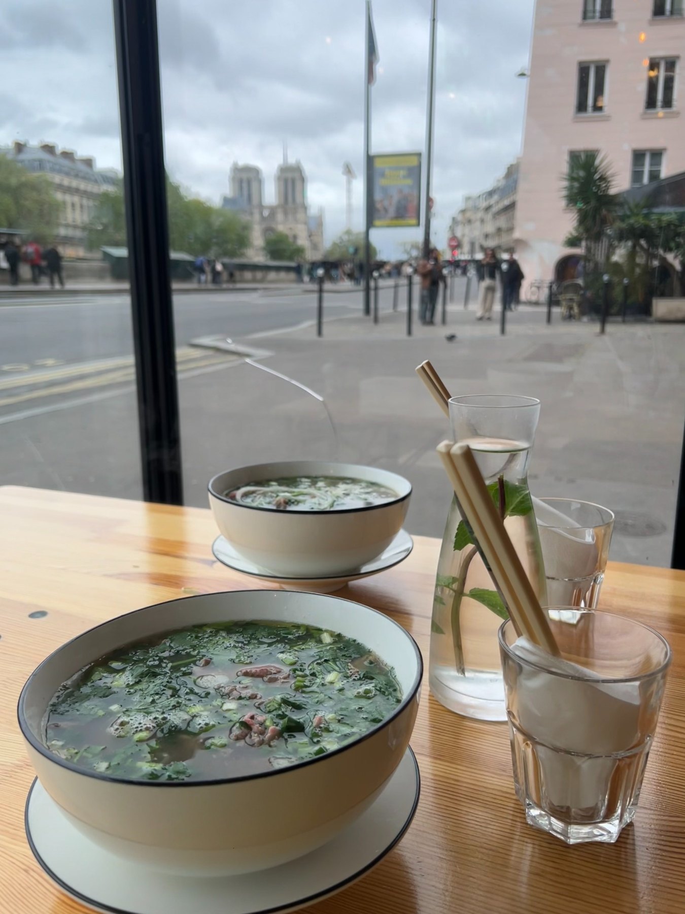 Bowl of phở by the window facing Notre-Dame